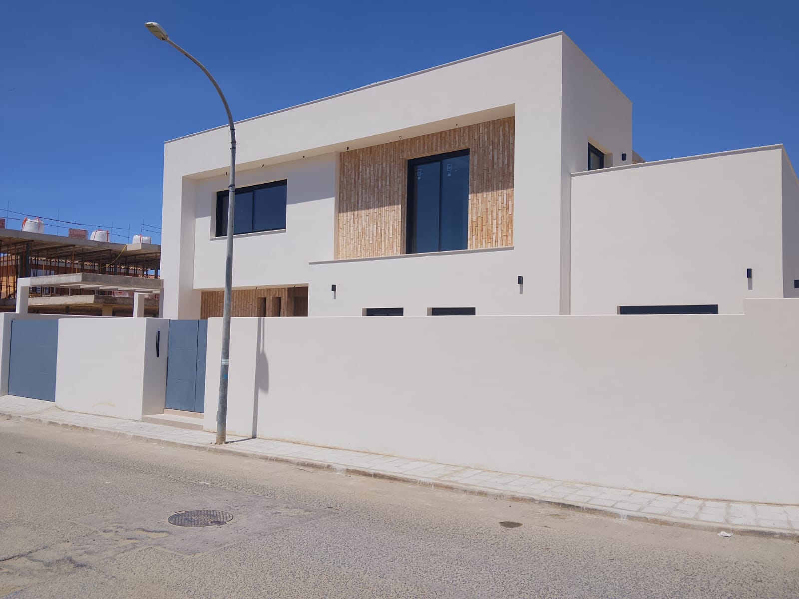 Fachada principal de la vivienda terminada, de día