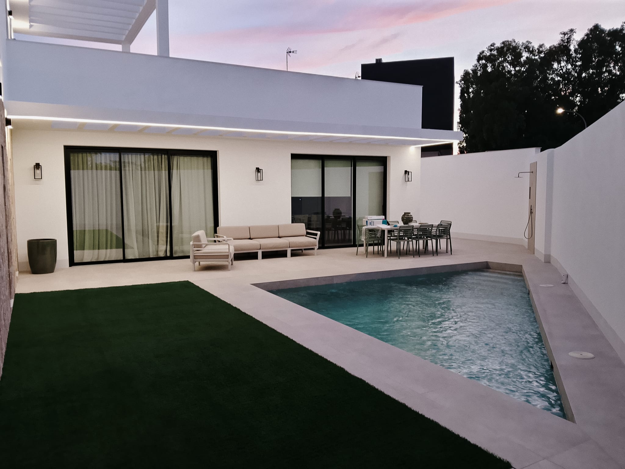 Patio con piscina, porche y salón abierto al exterior